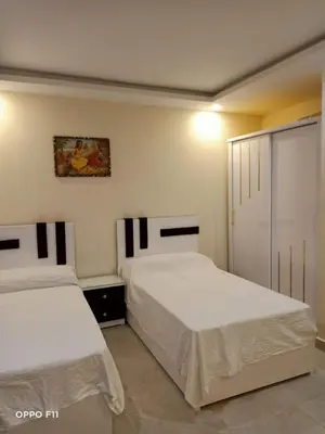 a bedroom with two beds and a sliding glass door at ميراج باى in Hurghada