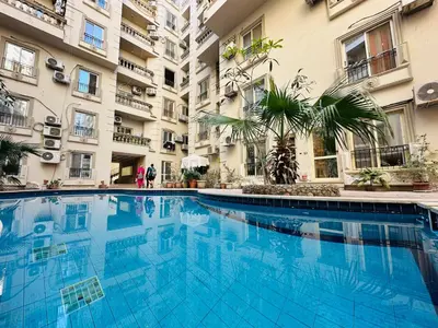 a swimming pool in front of a building at Cleopatra Style City Center in Hurghada