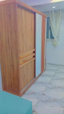 a large wooden cabinet in a room with marble floors at أهلا بكم in Luxor