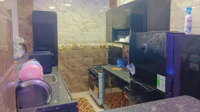 a kitchen with a black refrigerator and a stove at أهلا بكم in Luxor
