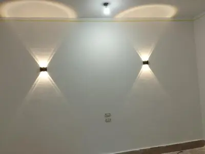 a wall with three lights on the wall at منزل خاص غرفتين 2 حمام صاله مطبخ امريكي جنينه خاصه سلم خارجي رووڤ in Al Aqālitah
