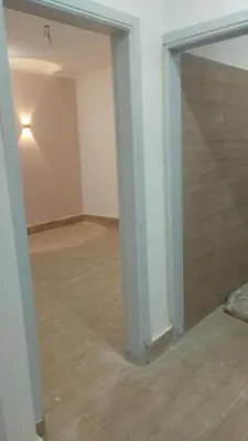 an empty room with a wooden floor and a wall at منزل خاص غرفتين 2 حمام صاله مطبخ امريكي جنينه خاصه سلم خارجي رووڤ in Al Aqālitah