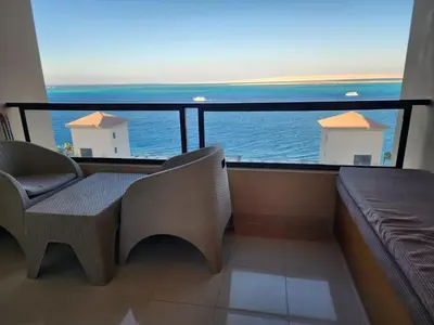 a balcony with a couch and a view of the ocean at Studil for rent in the view 608 in Hurghada