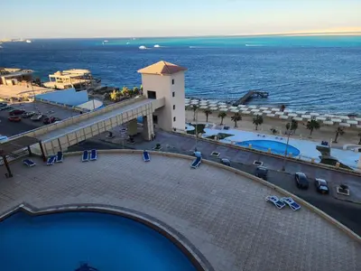 a view of a resort with a swimming pool and the ocean at Studil for rent in the view 608 in Hurghada