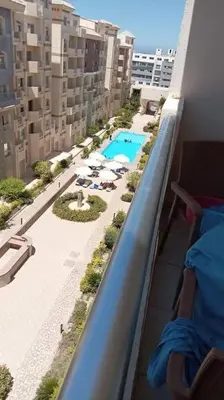 a balcony with a view of a pool and buildings at Florenza Resort in Hurghada