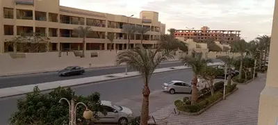 a city street with cars parked in front of a building at Florenza Resort in Hurghada