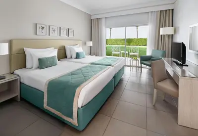 a hotel room with a large bed and a desk at JAZ Aquaviva in Hurghada
