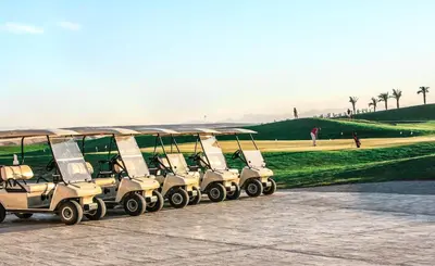 a group of golf carts parked next to a field at JAZ Aquaviva in Hurghada
