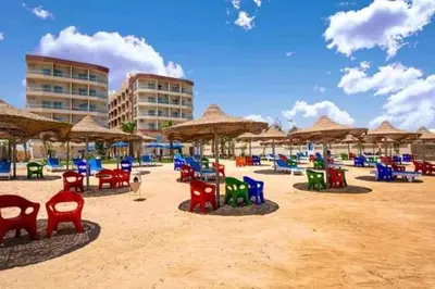 a beach with colorful chairs and umbrellas on the sand at Casablanca Beach for families only in Hurghada