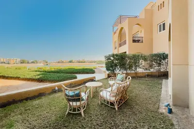 a patio with chairs and a table in front of a building at The 2BDR Warmhearted Waterside Apt in Hurghada