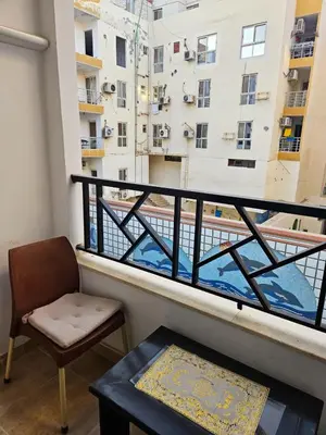 a balcony with a chair and a table and a window at Sheraton Plaza 218 in Hurghada