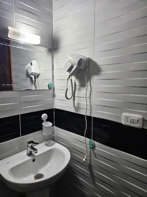 a bathroom with a sink and a phone on the wall at Sheraton Plaza 218 in Hurghada