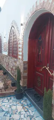 a red door in a building with potted plants at ZAIN PALACe in Jazīrat al ‘Awwāmīyah