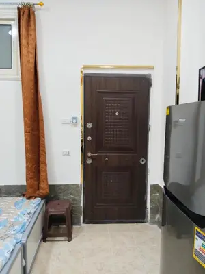 a brown door in a room with a refrigerator at الغردقه منطقه الاحياء in Hurghada