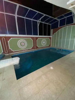 a swimming pool in a room with a tile wall at Villa with private pool A F in Hurghada