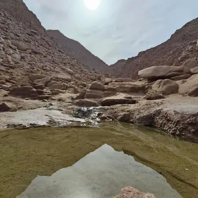 a pool of water in a canyon with rocks at Oasis Apartment in Safaga