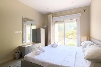a bedroom with a large white bed with a mirror at Joubal 2BR • Premium Ground Floor in Hurghada