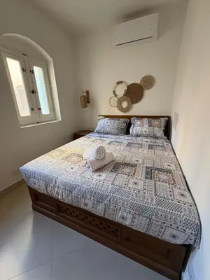 a bedroom with a bed with a comforter and a window at Cozy 1BR in the Heart of Gouna in Hurghada