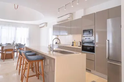a white kitchen with a sink and a refrigerator at Luxury 5BD Villa with Pool in Hurghada