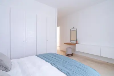 a white bedroom with a bed and a mirror at Luxury 5BD Villa with Pool in Hurghada