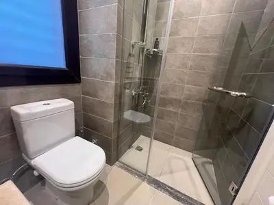 a bathroom with a toilet and a glass shower at Luxury 4BR Cyan Villa • Private Pool in Hurghada