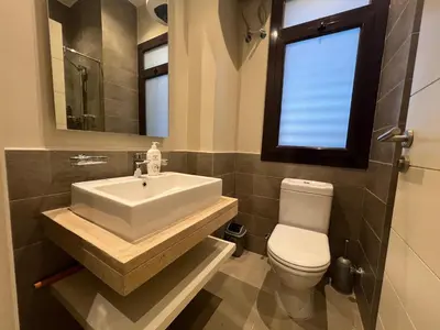 a bathroom with a sink and a toilet and a window at Luxury 4BR Cyan Villa • Private Pool in Hurghada