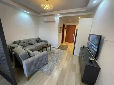 a living room with a couch and a flat screen tv at Alhambra Avenue in Hurghada