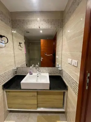 a bathroom with a sink and a person in a mirror at Alhambra Avenue in Hurghada