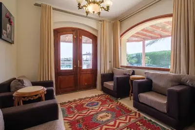 a living room with two chairs and a door at Serene 4BR Villa • Authentic West Golf in Hurghada