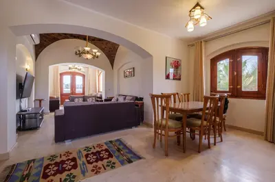 a living room with a table and chairs and a couch at Serene 4BR Villa • Authentic West Golf in Hurghada