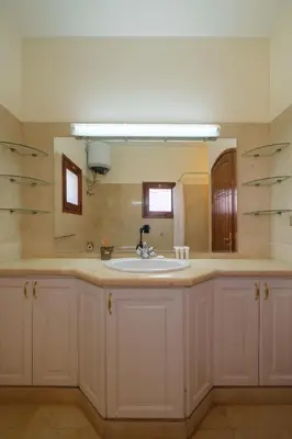 a bathroom with a sink and a mirror at Serene 4BR Villa • Authentic West Golf in Hurghada
