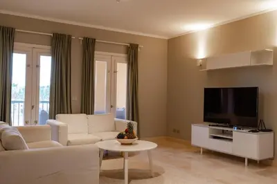 a living room with a white couch and a flat screen tv at 2BR New Marina Bliss • Cozy Centered Stay in Hurghada