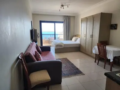 a living room with a bedroom with a bed and a couch at Studio for rent in the view 409 in Hurghada