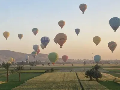 a bunch of hot air balloons flying over a field at Asmara Apartment Hatshepsut in Naj‘ al Madāmūd