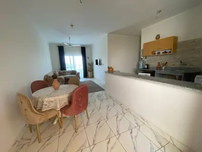 a kitchen and dining room with a table and chairs at Asmara Apartment Hatshepsut in Naj‘ al Madāmūd