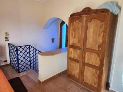 a room with a wooden cabinet next to a staircase at 2BD Apt, Douplex, 2 floors, Villa Yanny, El Helal, Hurghada in Hurghada