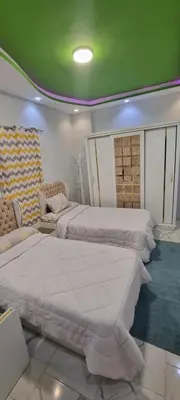 a bedroom with two beds and a green ceiling at Turtles Beach Resort Al Ahyaa in Hurghada