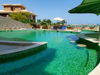 a swimming pool with green water in a resort at Turtles Beach Resort Al Ahyaa in Hurghada