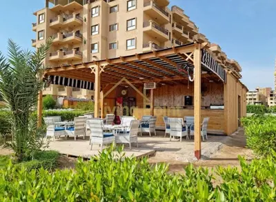 a pavilion with chairs and tables in front of a building at Turtles Beach Resort Al Ahyaa in Hurghada