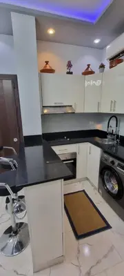 a kitchen with white cabinets and a black counter top at Turtles Beach Resort Al Ahyaa in Hurghada