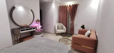 a bedroom with a bed and a mirror and a chair at Florenze Khamsin Hurghada in Hurghada