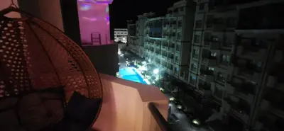 a balcony with a view of a city at night at Florenze Khamsin Hurghada in Hurghada