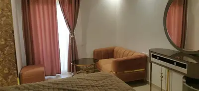a bedroom with a bed and a mirror and a couch at Florenze Khamsin Hurghada in Hurghada