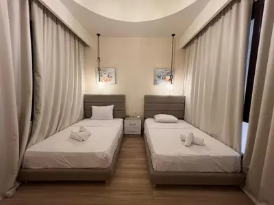 two beds in a room with white curtains at Ancient Sands 4BR • Heated Pool Twin-Villa in Hurghada