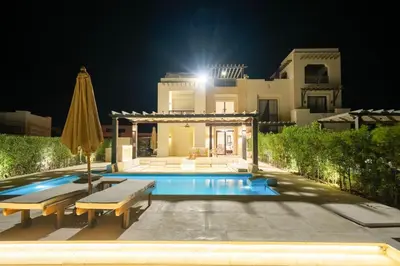 a villa with a swimming pool at night at Ancient Sands 4BR • Heated Pool Twin-Villa in Hurghada