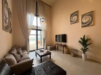 a living room with a couch and a tv at Ancient Sands 4BR • Heated Pool Twin-Villa in Hurghada