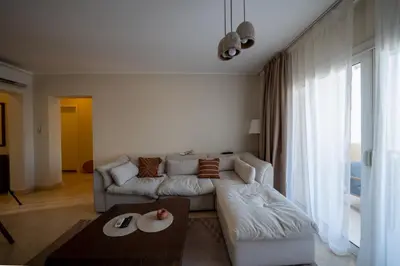 a living room with a couch and a table at Joubal 2BR • Top Floor Lagoon View in Hurghada