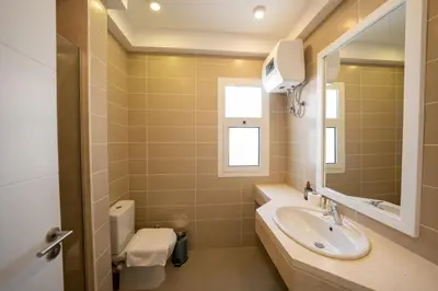 a bathroom with a sink and a mirror at Joubal 2BR • Top Floor Lagoon View in Hurghada