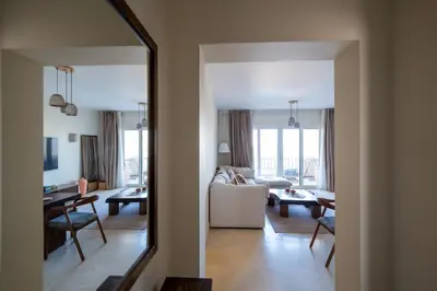 a living room with a mirror and a couch at Joubal 2BR • Top Floor Lagoon View in Hurghada