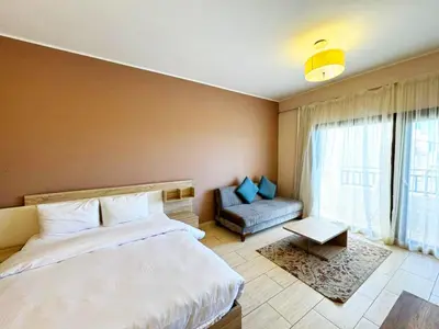 a bedroom with a bed and a couch and a window at Sea View Aldau Hights in Hurghada